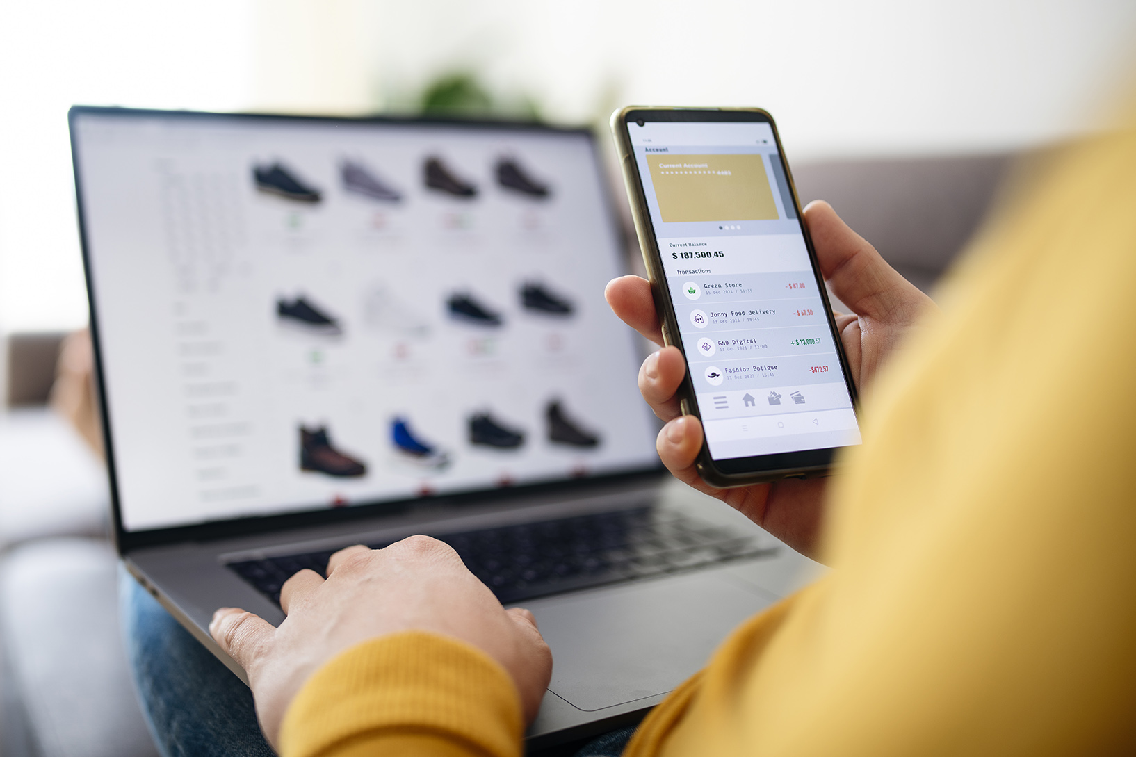 A person makes an online purchase with their computer and mobile phone