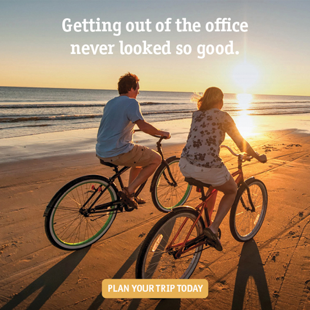 Couple biking on beach at sunset