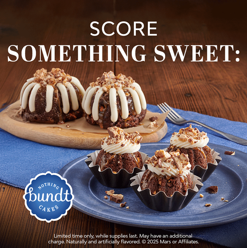 Snickers bundt cakes topped with frosting and chopped peanuts