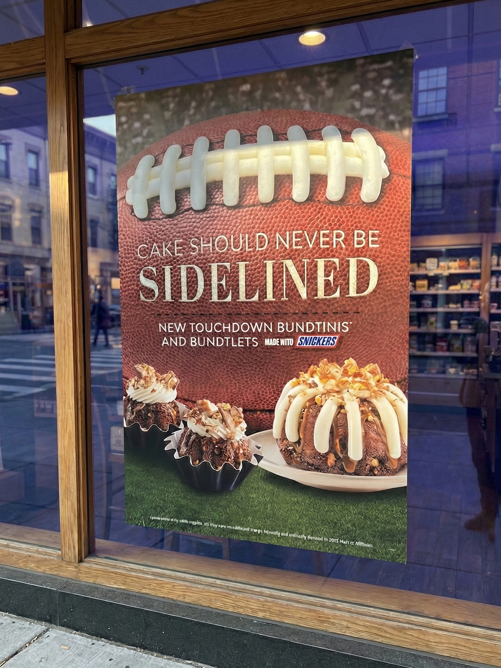 Window display poster featuring football-themed bundt cakes