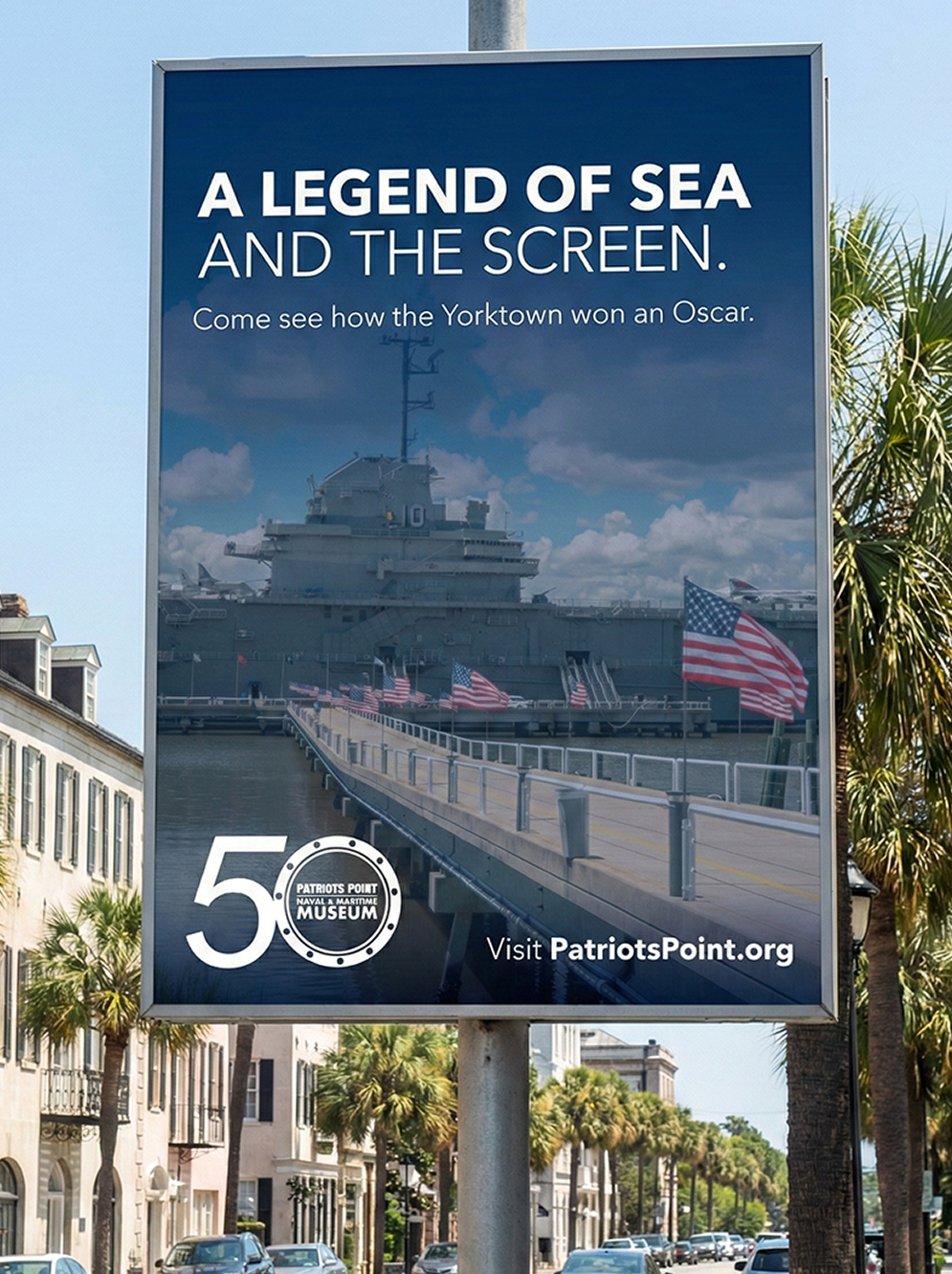 Billboard showing USS Yorktown and pier with American flags
