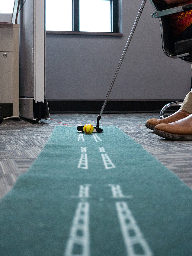 Office putting green with golf ball and putter